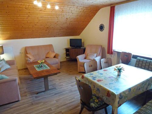 ein Wohnzimmer mit einem Tisch und Stühlen sowie ein Esszimmer in der Unterkunft Apartment Haus Silberdistel by Interhome in Gersbach