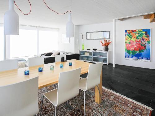 a living room with a wooden table and white chairs at Apartment Melina by Interhome in Laax