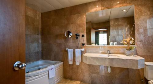 
a bathroom with a tub, sink and mirror at Hotel Aristol - Sagrada Familia in Barcelona
