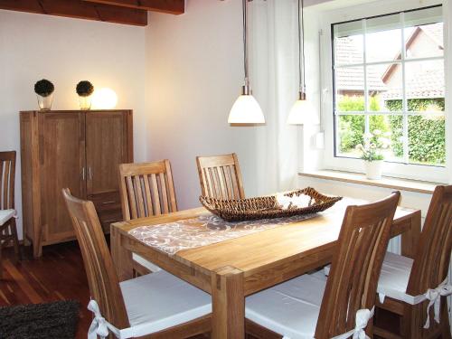 a dining room with a wooden table and chairs at Holiday Home Johanna by Interhome in Hooksiel