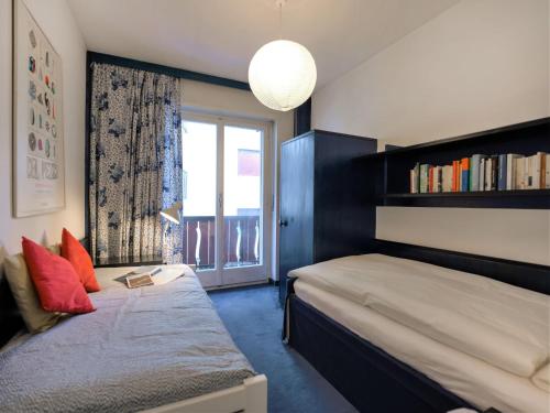 ein Schlafzimmer mit einem Bett und einem Fenster mit einem Bücherregal in der Unterkunft Apartment Chesa Romantica 17 by Interhome in St. Moritz