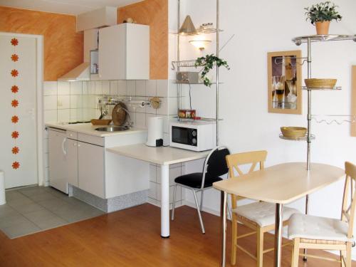 een kleine keuken met een tafel en 2 stoelen bij Apartment Tossens-6 by Interhome in Tossens