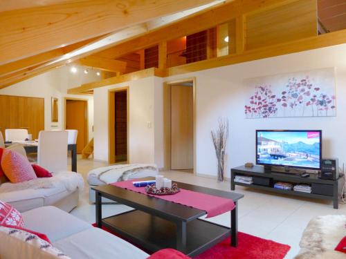 a living room with a couch and a tv at Apartment Staubbach by Interhome in Lauterbrunnen