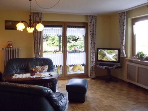 a living room with a couch and a television at Apartment Tillisch by Interhome in Sasbachwalden