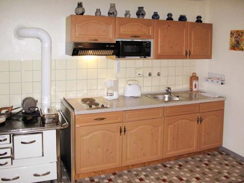 a kitchen with wooden cabinets and a sink at Apartment Tillisch by Interhome in Sasbachwalden
