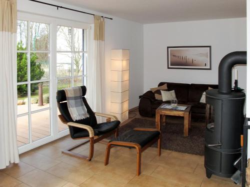 a living room with a wood stove and a couch at Holiday Home Katja by Interhome in Ostseebad Karlshagen