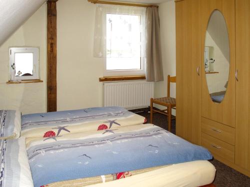a bedroom with a bed and a mirror and a window at Apartment Am Strom-4 by Interhome in Ummanz