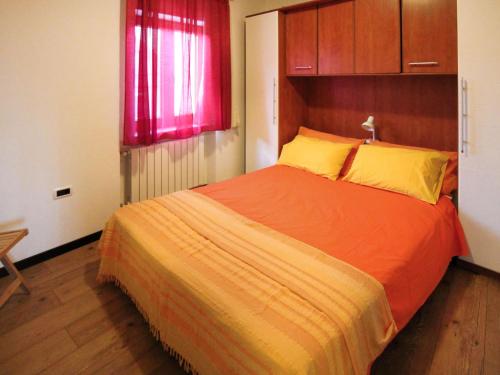 1 dormitorio con 1 cama grande de color naranja con cortinas rojas en Apartment Lina - PUL458 by Interhome, en Šišan