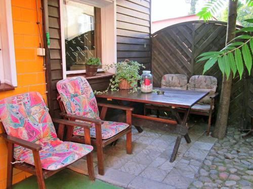 einen Holztisch und Stühle auf einer Terrasse in der Unterkunft Holiday Home Mały Domek by Interhome in Darłowo