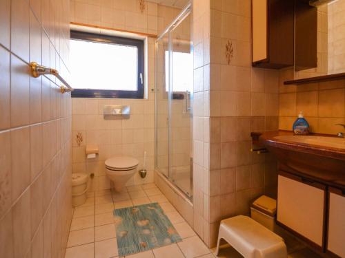 a bathroom with a shower and a toilet and a sink at Apartment Windrose by Interhome in Burhave