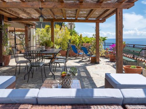 un patio con sofá, mesa y sillas en Holiday Home Villa Peiranze by Interhome, en San Remo