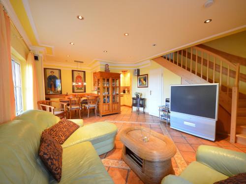 ein Wohnzimmer mit einem Sofa und einem großen TV in der Unterkunft Holiday Home Kirchhaus by Interhome in Groß Zicker