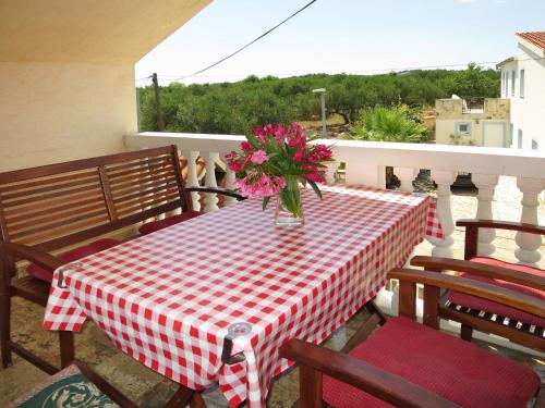 a table with a vase of flowers on a balcony at Apartment Ivamar-2 by Interhome in Jezera