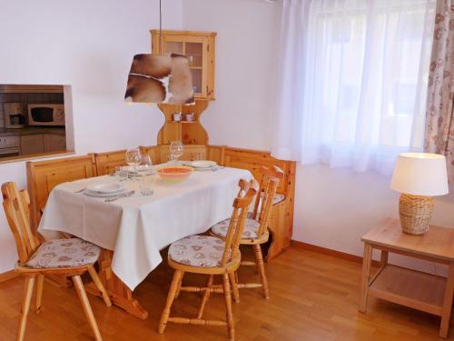 een eettafel met een wit tafelkleed en stoelen bij Apartment Chesa Sur Val 22 by Interhome in St. Moritz