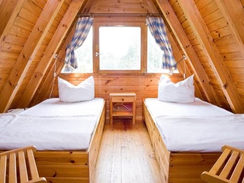 2 camas en una cabaña de madera con ventana en Holiday Home Geesthof-8 by Interhome en Klint
