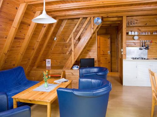 een eetkamer met blauwe stoelen en een houten tafel bij Holiday Home Geesthof-8 by Interhome in Klint