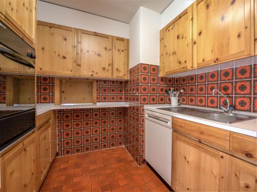 a kitchen with wooden cabinets and a sink at Apartment Chesa La Sajetta 12 by Interhome in Surlej