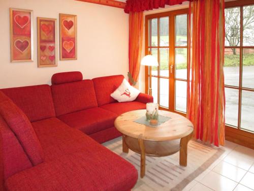 sala de estar con sofá rojo y mesa en Apartment Wiedenberg by Interhome en Tonbach