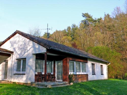 Casa blanca pequeña con porche y sillas en Holiday Home Kyrbach by Interhome en Liederbach