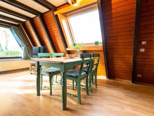 a dining room with a green table and chairs at Holiday Home Ferienwohnpark Immenstaad-3 by Interhome in Immenstaad am Bodensee
