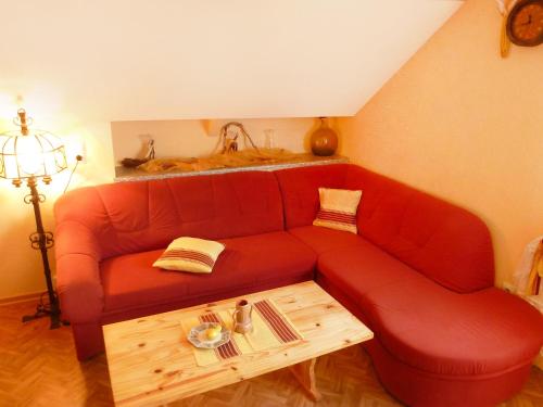 uma sala de estar com um sofá vermelho e uma mesa em Apartment Allmendgasse by Interhome em Schelingen