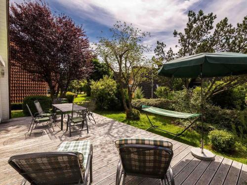 a patio with a table and chairs and an umbrella at Holiday Home Ferienwohnpark Immenstaad-1 by Interhome in Immenstaad am Bodensee
