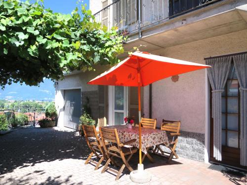 un tavolo con ombrellone rosso su un patio di Apartment Casa Riboni by Interhome a Luino