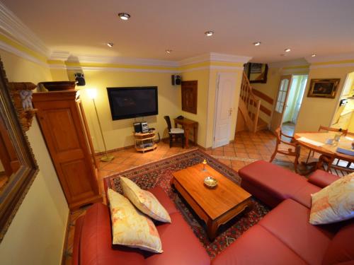 ein Wohnzimmer mit einem roten Sofa und einem Tisch in der Unterkunft Holiday Home Lotsenhaus by Interhome in Groß Zicker