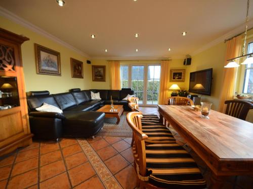 ein Wohnzimmer mit einem schwarzen Sofa und einem Tisch in der Unterkunft Holiday Home Seeadler by Interhome in Groß Zicker