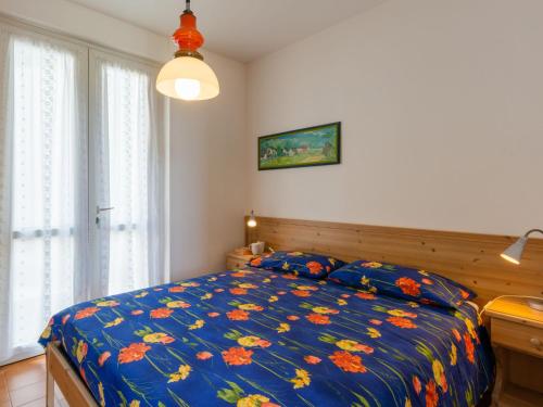 a bedroom with a bed with a blue comforter at Holiday Home Ronco - VNA216 by Interhome in Perledo