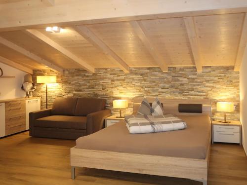 sypialnia z łóżkiem, kanapą i krzesłem w obiekcie Apartment Spieglhof-3 by Interhome w mieście Sarntal