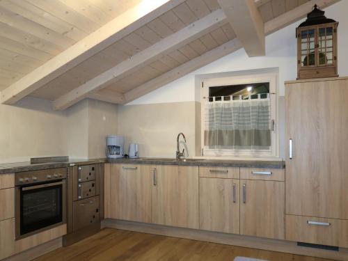 a large kitchen with wooden cabinets and a window at Apartment Spieglhof-3 by Interhome in Sarntal