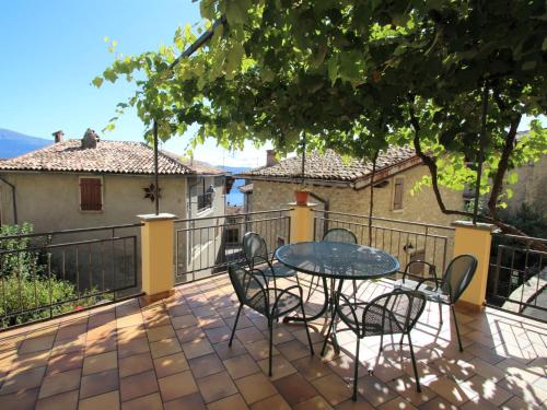 un patio con tavolo e sedie sul balcone. di Apartment Formaga-1 by Interhome a Gargnano