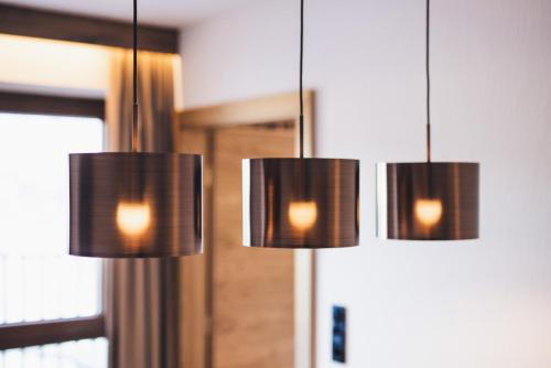two chandeliers hanging in front of a mirror at Alpenperle Apartments in Ladis
