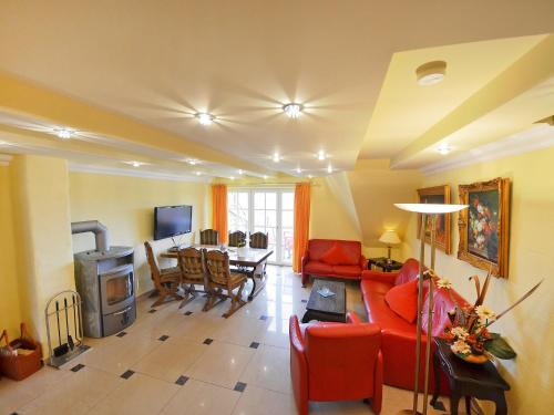 ein Wohnzimmer mit einem roten Sofa und einem Tisch in der Unterkunft Apartment Sonnenkamp-4 by Interhome in Groß Zicker