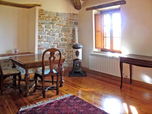 un soggiorno con tavolo in legno e parete in pietra di Holiday Home Casa Ingrid by Interhome a San Venanzo