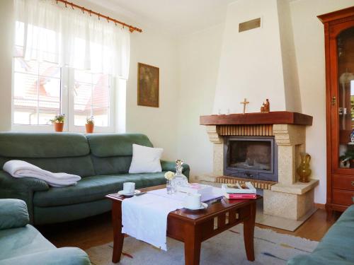 a living room with a green couch and a fireplace at Holiday Home Mały dworek by Interhome in Łeba