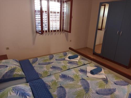 a bedroom with a bed with towels and a mirror at Apartments Kornati in Ždrelac