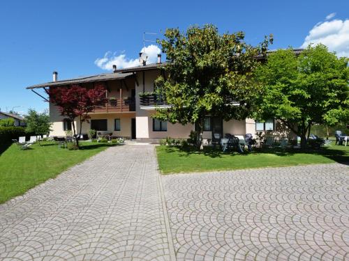 a house with a brick driveway in front of a building at Apartment Agostini-1 by Interhome in Caldonazzo