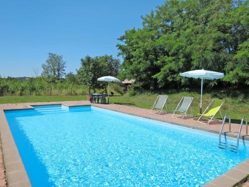a swimming pool with chairs and umbrellas and a table at Holiday Home Pasqualino by Interhome in Bagnoregio