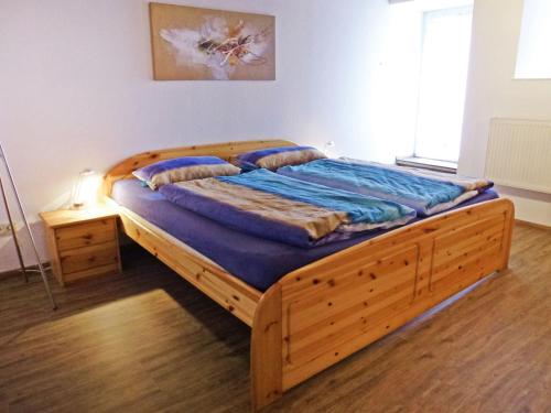 Schlafzimmer mit einem Holzbett mit blauer Bettwäsche in der Unterkunft Apartment Schuler by Interhome in Unterkirnach