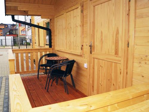 Cabaña de madera con 2 sillas y mesa en el porche en Holiday Home Onyx-1 by Interhome, en Mielenko