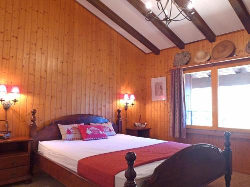 um quarto com uma cama com paredes de madeira e uma janela em Apartment Parc B 431 by Interhome em Champex