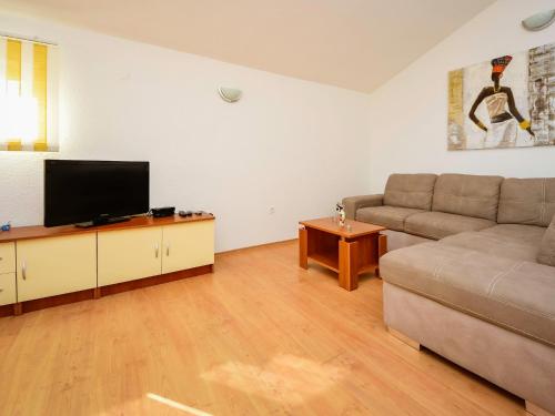 ein Wohnzimmer mit einem Sofa und einem Flachbild-TV in der Unterkunft Apartment Pusa by Interhome in Sveti Filip i Jakov