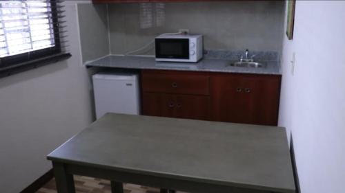 a small kitchen with a table and a microwave at Hospedaje J.R in Chitré