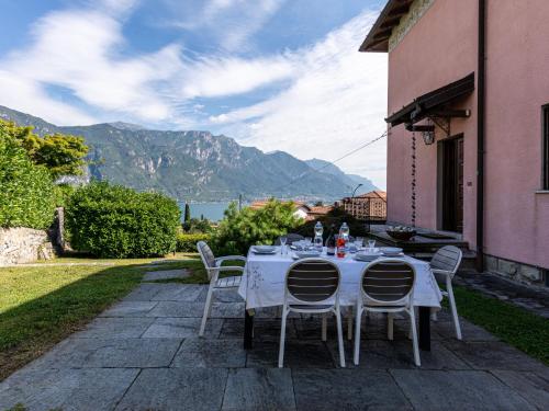 a table and chairs on a patio with mountains at Villa Vittoria by Interhome in Bellagio
