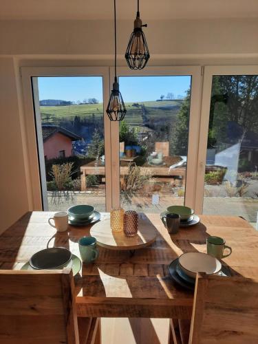 a dining room table with a view of a yard at Große Auszeit Eifel mit Sauna, Kamin und Terrasse in Nettersheim
