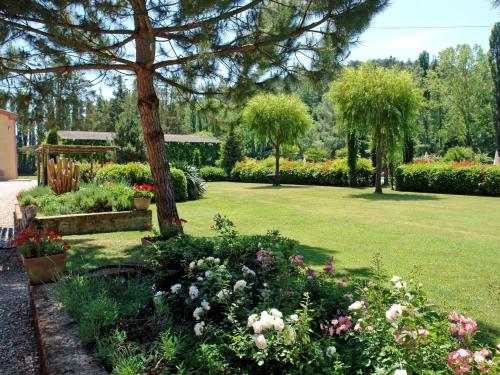 un jardín con muchas flores y árboles en Villa Il Cipresso by Interhome, en Marti