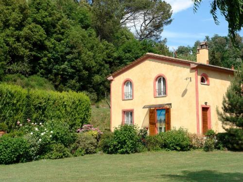 uma pequena casa num quintal com arbustos e árvores em Villa Il Cipresso by Interhome em Marti