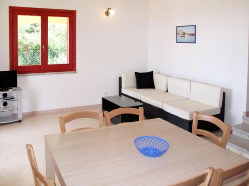 un soggiorno con tavolo e divano di Holiday Home Case Greche Basse - REI235 by Interhome a Costa Rei